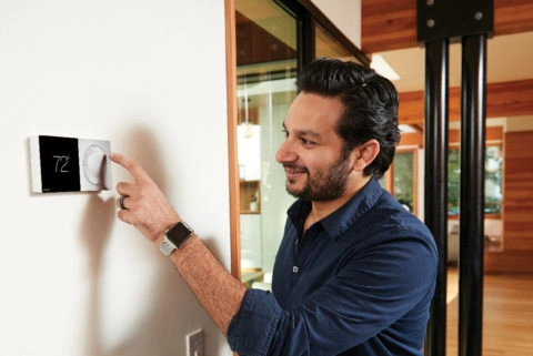 Man setting a smart thermostat